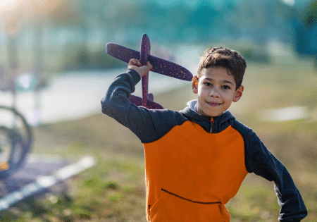 child flying a foam glider