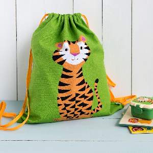 Teddy the Tiger Drawstring bag filled with items leaning against a wallwith items against a wall Teddy the Tiger Drawstring bag filled with items leaning against a wall