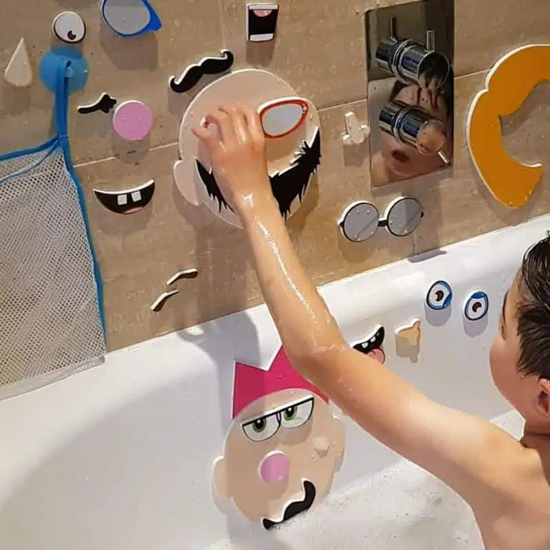 boy playing with silly faces bath stickers